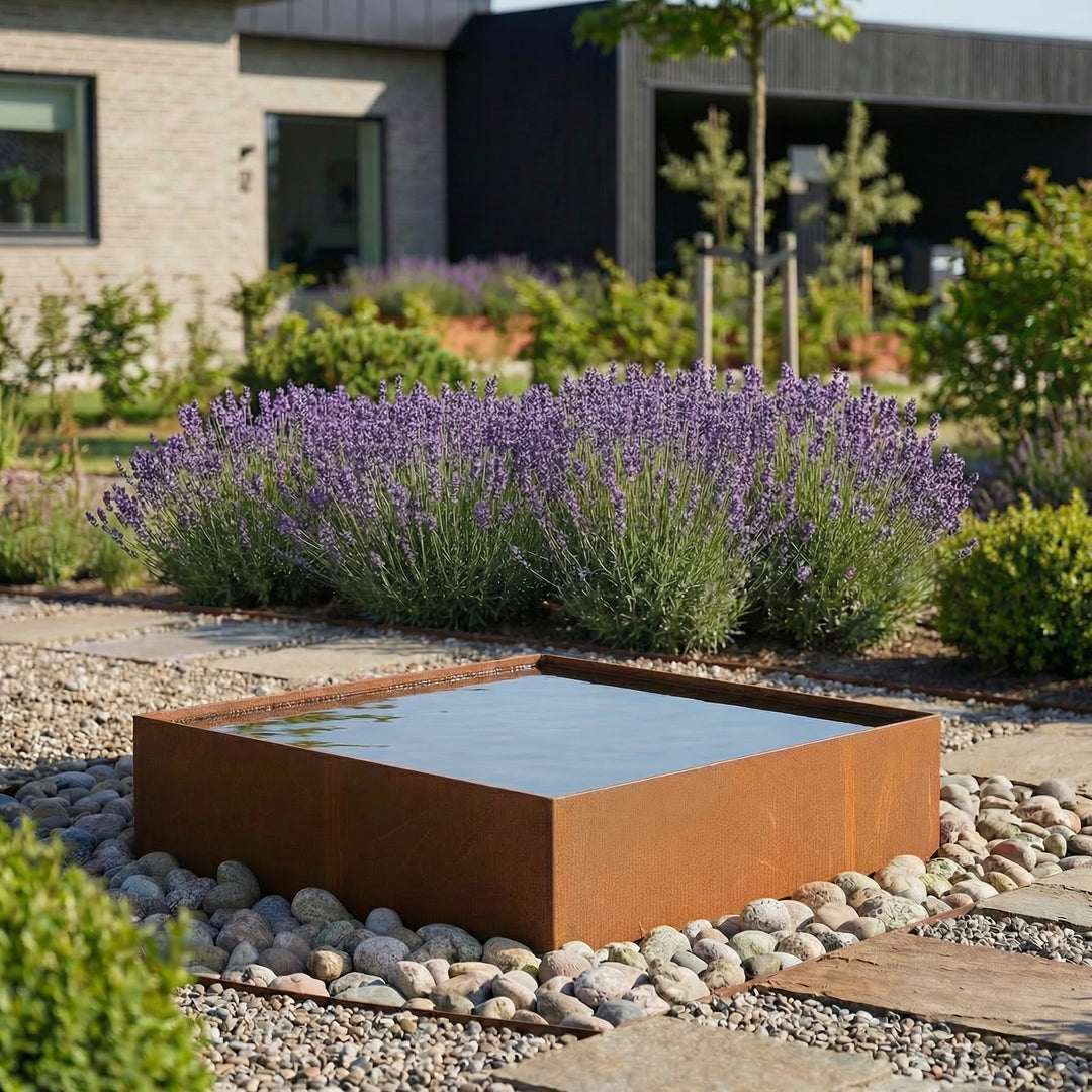 Eine quadratische Wasserbecken aus cortenstahl in einem schönen garten.  