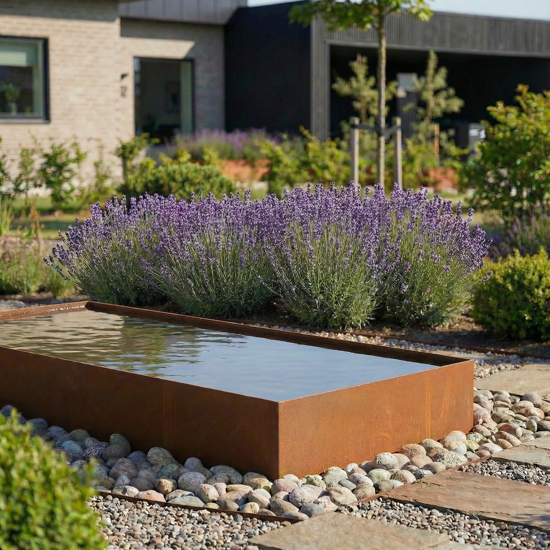 Eine lange Wasserbecken aus cortenstahl in einem schönen garten.  